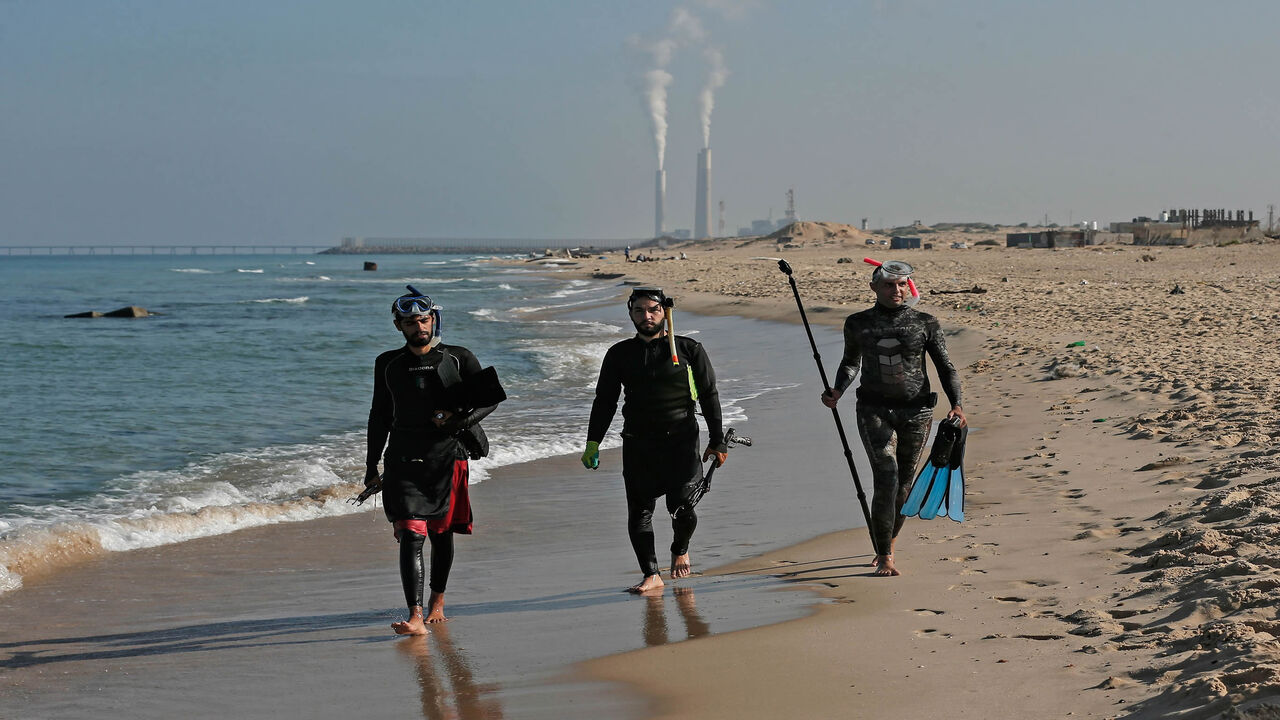 1229085550 TOPSHOT - Palestinian spear-fishermen prepare to dive with an underwater photographer in the Mediterranean Sea, off the coast of Khan Yunis, in the southern Gaza Strip on October 15, 2020. (Photo by MAHMUD HAMS / AFP) (Photo by MAHMUD HAMS/AFP via Getty Images)