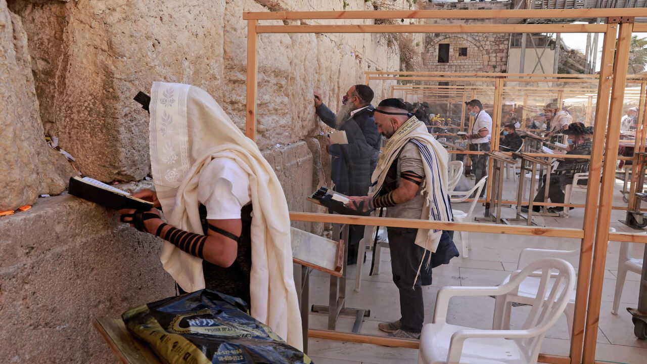 1231336829 Ultra-orthodox Jewish men, some wearing the traditional Jewish prayer shawls known as Tallit, pray in divided sections at the Western Wall in Jerusalem's old city on February 23, 2021. (Photo by MENAHEM KAHANA / AFP) (Photo by MENAHEM KAHANA/AFP via Getty Images)