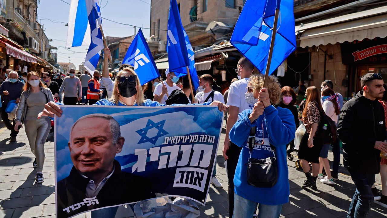 1231392420 Supporters of Israeli Prime Minister Benjamin Netanyahu campaign at the Mahane Yehuda market in Jerusalem on February 26, 2021 ahead of the March 23 Israel general election. - Israel will hold its fourth general election in less than two years, on March 23. (Photo by MENAHEM KAHANA / AFP) (Photo by MENAHEM KAHANA/AFP via Getty Images)