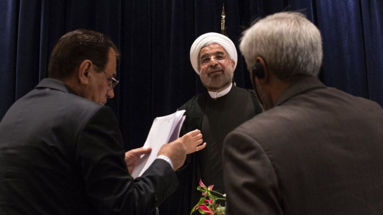 Iran's President Rouhani is approached by staff members after a news conference in New York Iran's President Hassan Rouhani (C) is approached by staff members after a news conference in New York September 27, 2013. New Iranian President Rouhani said on Friday he wanted talks with major powers on Iran's nuclear program to yield results in a short period of time and that the improved mood in U.S.-Iranian relations could lead to better ties. REUTERS/Adrees Latif (UNITED STATES - Tags: POLITICS ENERGY) - RTX142AH