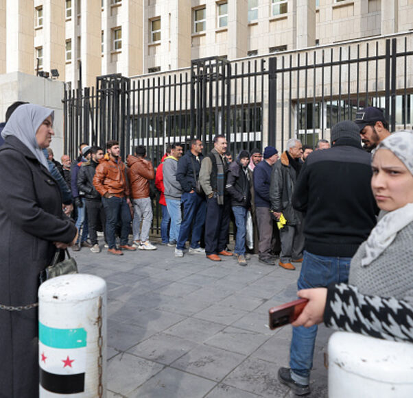 People queue outside the main headquarters of the Central Bank of Syria to exchange US dollars at prices lower than the black market, in Damascus on December 30, 2024. (Photo by ANWAR AMRO / AFP) (Photo by ANWAR AMRO/AFP via Getty Images)