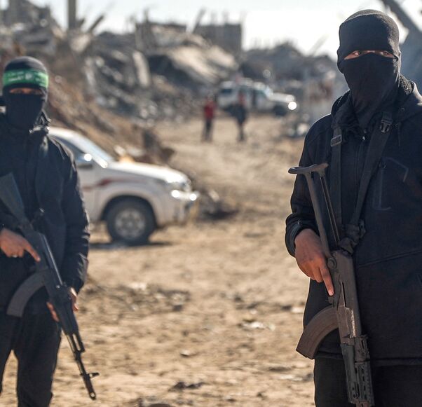 Palestinian Hamas militants secure the area as Egyptian workers, accompanied by members of the International Committee of the Red Cross, search for the last two remaining bodies of hostages from under the rubble of the Jabalia refugee camp, in the northern of Gaza Strip on Dec. 1, 2025. 