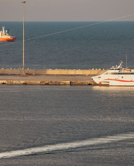A police speed boat patrols the port as oil tankers and high speed crafts sit anchored at Muscat Anchorage near the Strait of Hormuz on March 30, 2026 in Muscat, Oman.