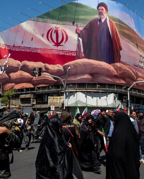 People gather under a large portrait of Iran's new Supreme Leader, Mojtaba Khamenei, during a memorial to mark the 40th day since his father, Ali Ayatollah Khamenei, was killed in US-Israeli joint strikes, on April 9, 2026, in Tehran, Iran.