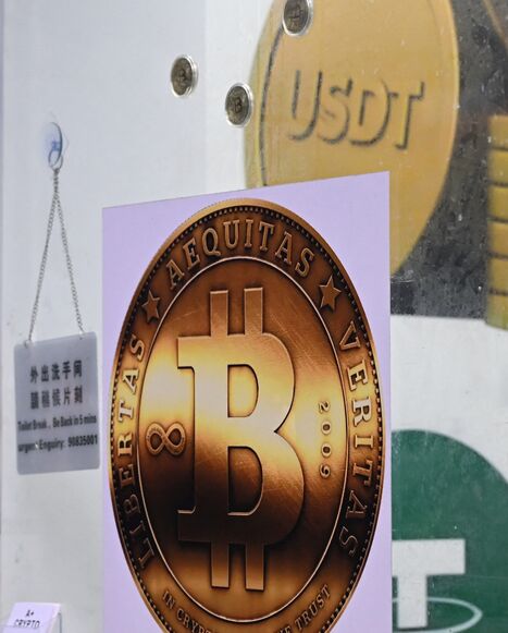 The symbols of bitcoin and the stablecoin Tether (USDT) are displayed at a cryptocurrency store in Hong Kong on July 29, 2025. 