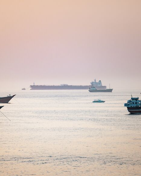 A tourist boat passes near crude oil tankers, bulk carriers, and other vessels anchored off Port Sultan Qaboos in Muscat, Oman, June 19, 2026. 
