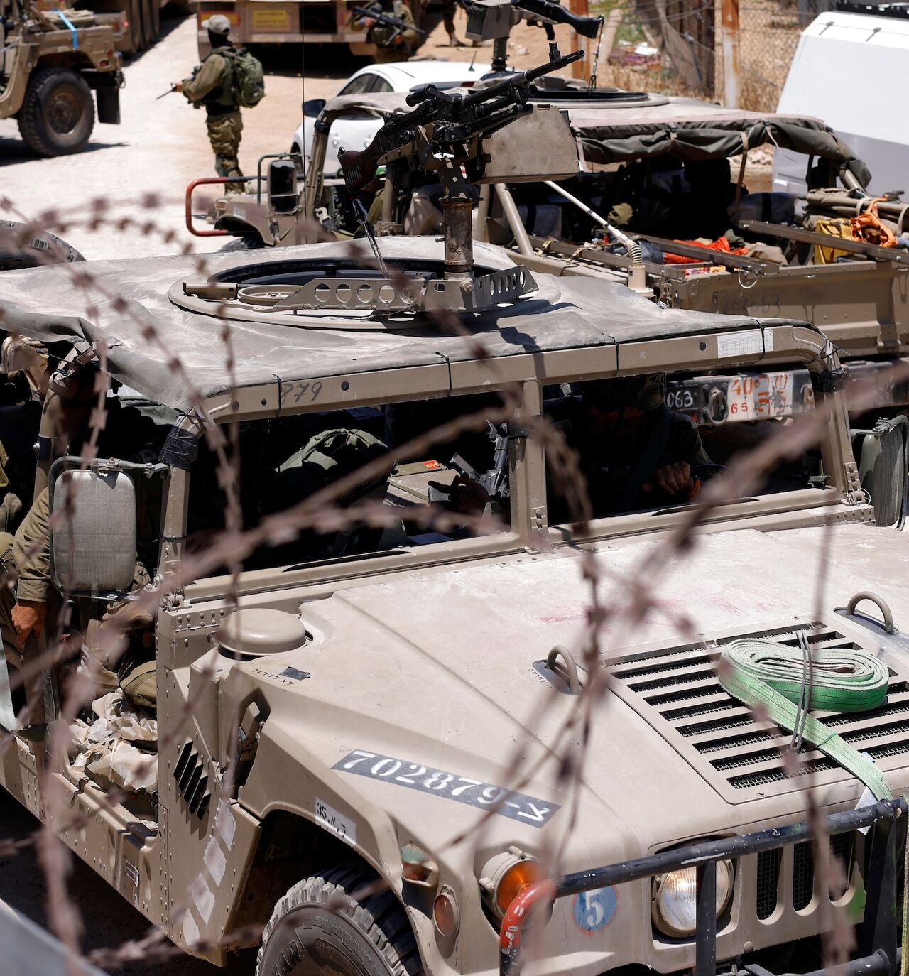 Israel military vehicles drive along the border fence with Syria, near the town of Majdal Shams, in the Israeli-annexed Golan Heights, July 17, 2025.