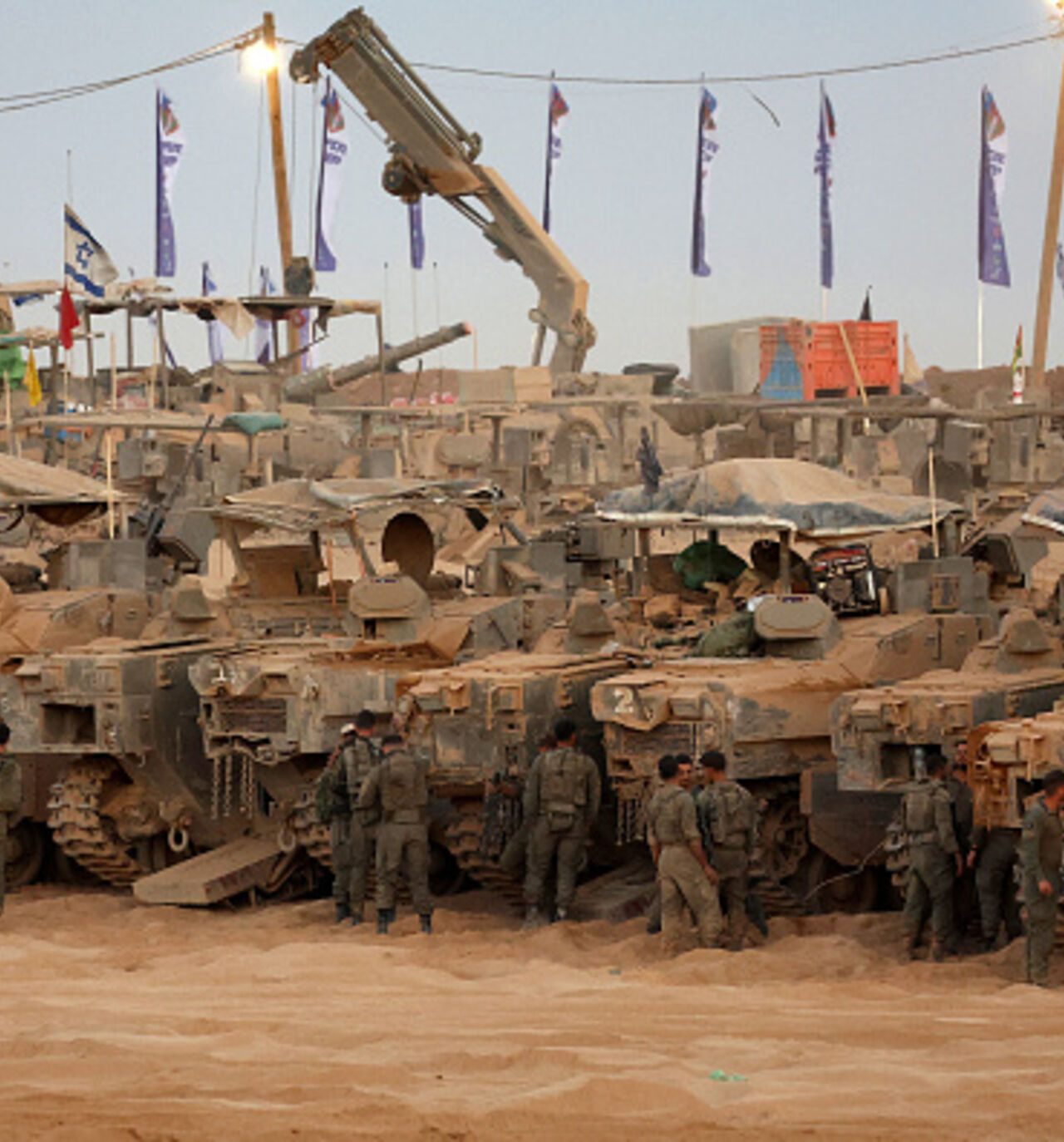 Israeli army soldiers gather near infantry-fighting vehicles (IFVs) at a position along the Israel-Gaza border fence on October 10, 2025. Gaza's civil defence agency said October 10 that Israeli forces have begun pulling back from parts of the territory, particularly in Gaza City and Khan Yunis. Israeli prime minister's office said that the government had "approved the framework" of a hostage release deal with Hamas, as both sides edged closer to ending more than two years of hostilities in Gaza. (Photo by 