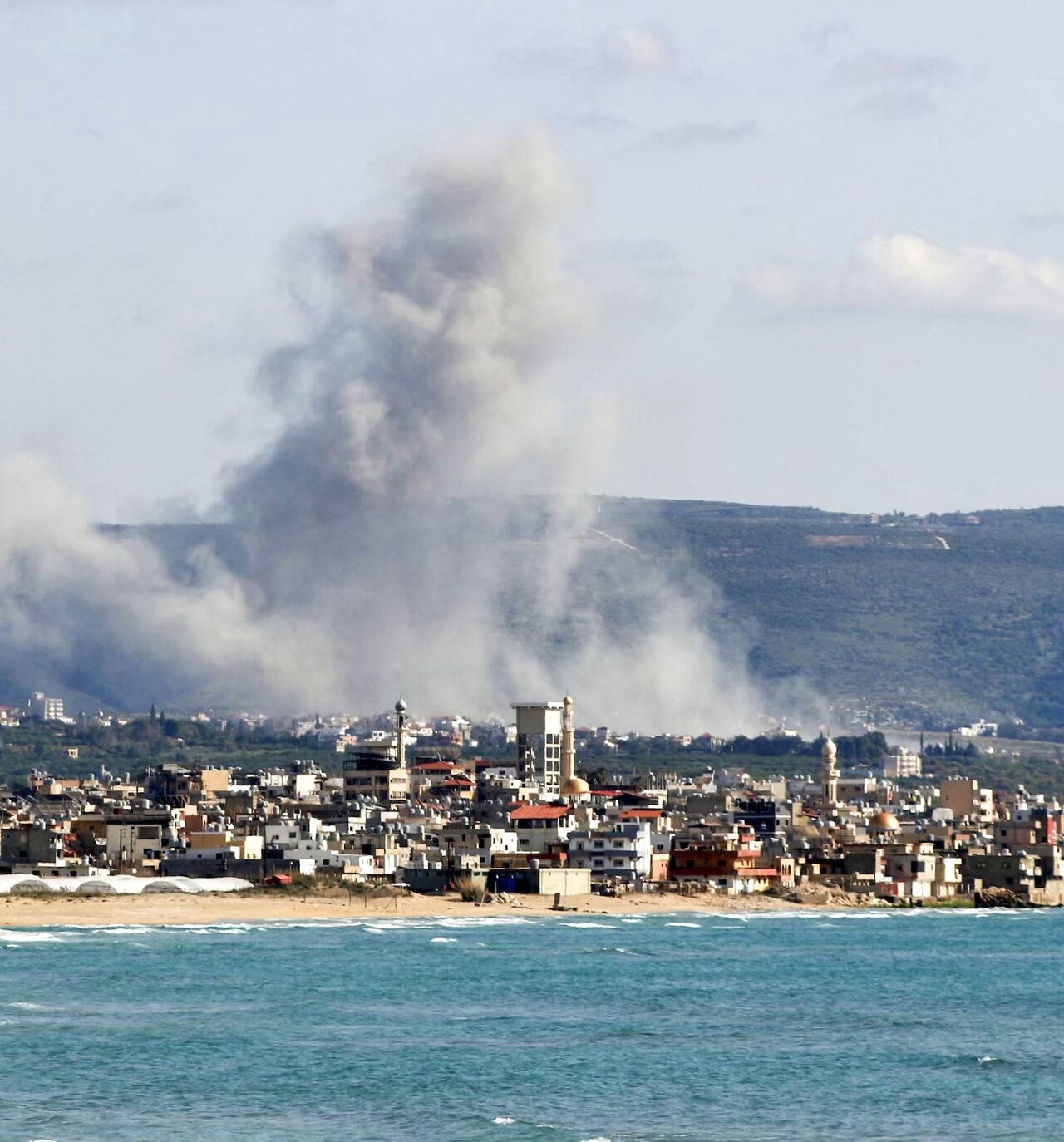 This photograph taken from the southern Lebanese area of Tyre shows smoke as it rises from the site of an Israeli airstrike that targeted the village of Qlaileh on April 13, 2026.