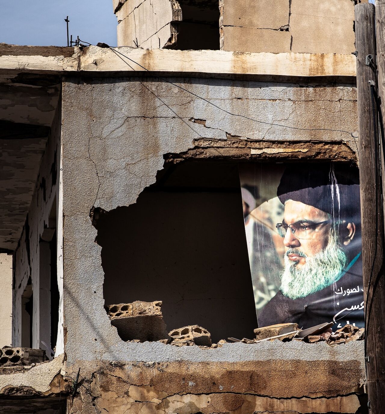 A portrait of the late Hezbollah leader Hassan Nasrallah is visible in heavily damaged building in the border town of Ayta al-Chaab, southern Lebanon, Feb. 21, 2026. 