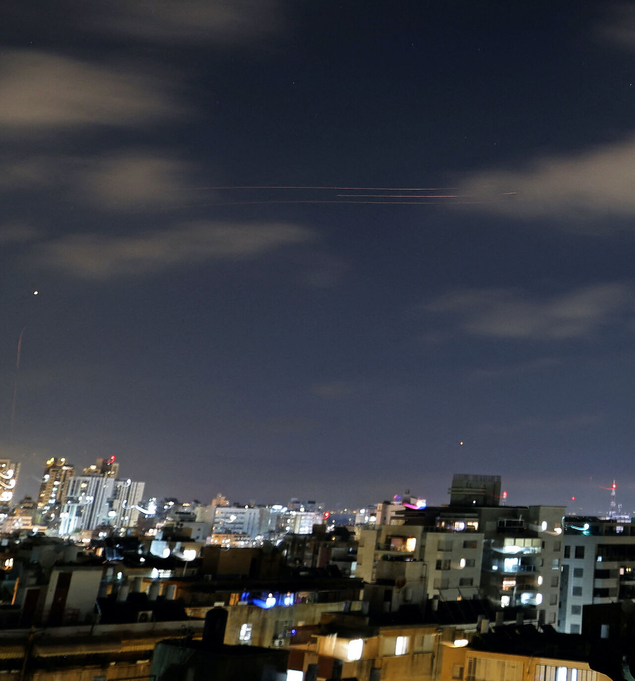 Rocket trails are seen in the sky above the Israeli coastal city of Netanya on June 7, 2026.