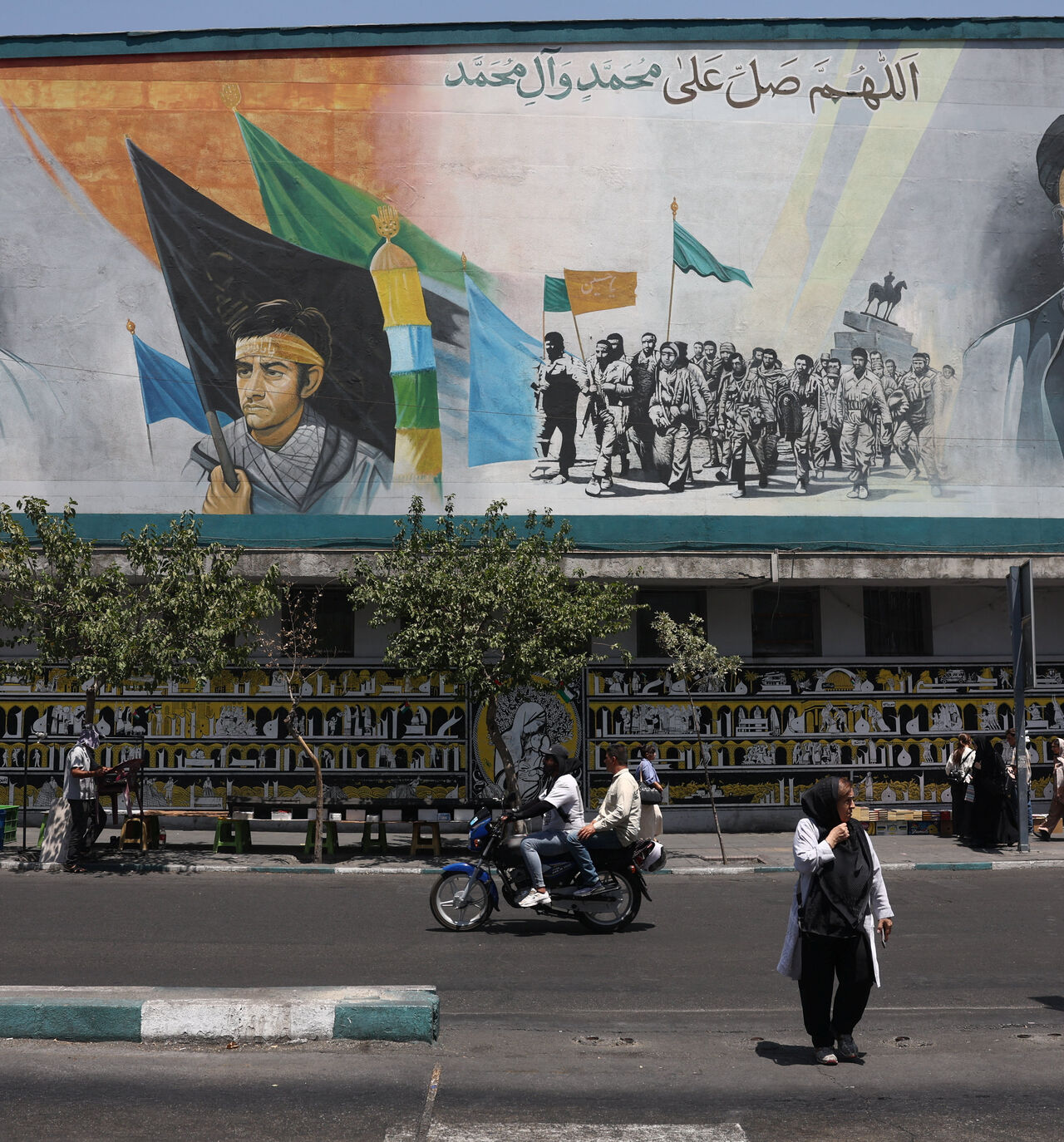People walk past a mural depicting the late leader of the Islamic Revolution, Ayatollah Ruhollah Khomeini, and Iran's late Supreme Leader Ayatollah Ali Khamenei, on a street in Tehran, Iran, July 15, 2026. Majid Asgaripour/WANA (West Asia News Agency) via REUTERS