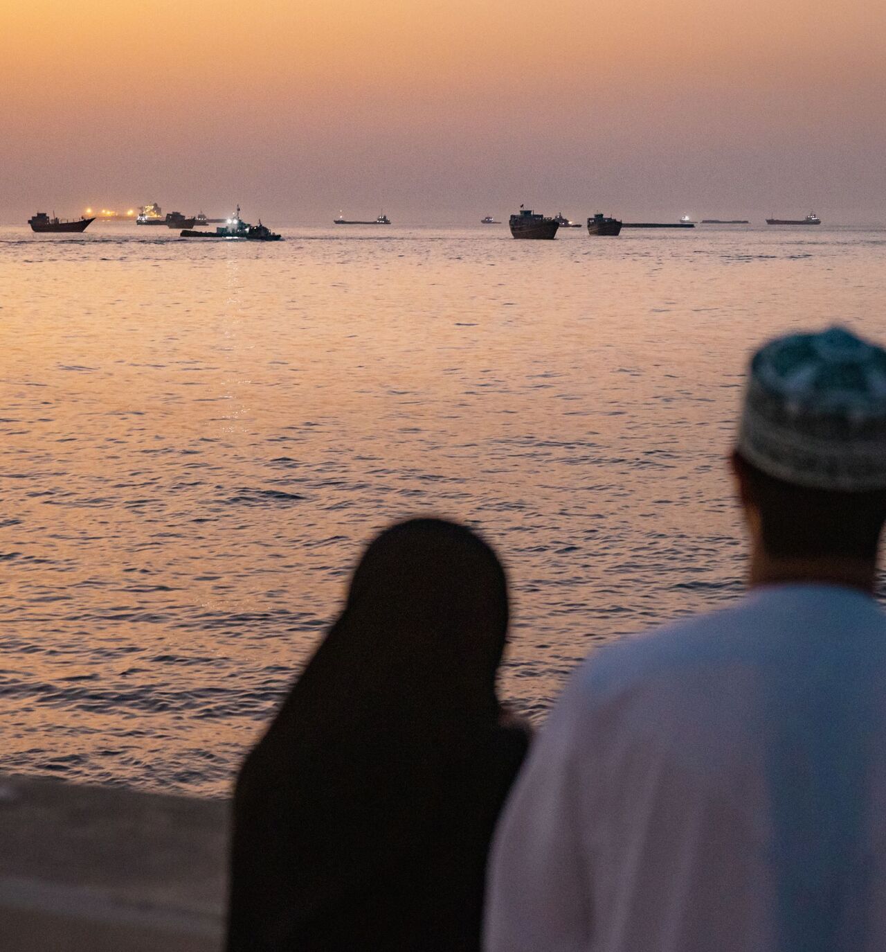 A couple watch oil tankers