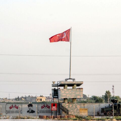 A Turkish military truck patrols next to a Turkish flag hoisted at the border with Syria on Aug. 14, 2019, in Akcakale, in Sanliurfa, southeastern Turkey. 