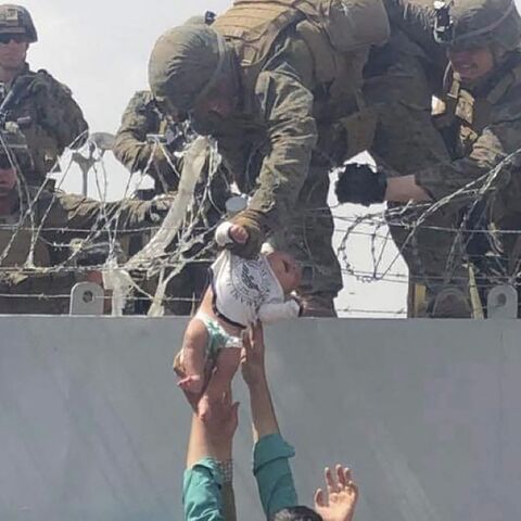 Marine grabs baby handed over wall at Kabul airport 