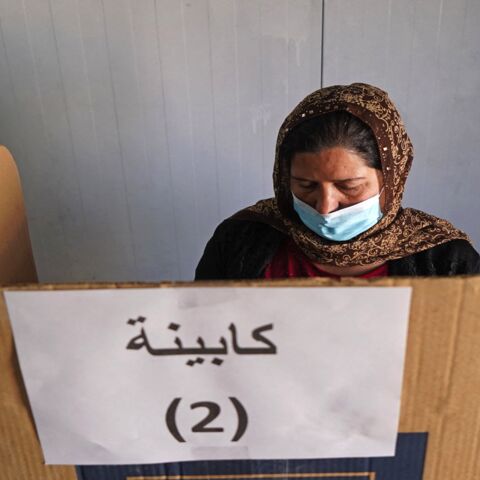 A displaced Yazidi casts her vote for the parliamentary elections at a camp some 15 kilometers from the northern city of Dahuk in the autonomous Iraqi Kurdistan region, on Oct. 8, 2021. 