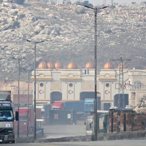 A convoy transporting humanitarian aid crosses into Syria from Turkey through the Bab al-Hawa border crossing on Jan. 18, 2022. 