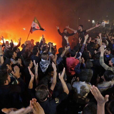 Demonstrators chant and burn tires as they gather in the Syrian opposition-held town of al-Bab.