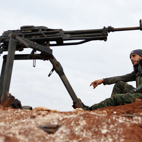 A Turkey-backed Syrian fighter sits at a position on the outskirts of the town of Marea.