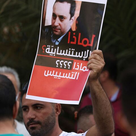 A supporter of Hezbollah and the Amal movements carries a portrait of Judge Tarek Bitar.