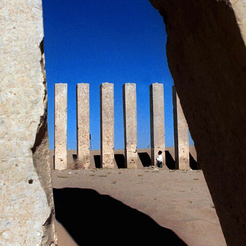 A Yemeni man looks up at pillars at the Awam, or Moon Temple, near the recently restored Arsh, or Throne of Balquis, the site of the legendary kingdom of Sheba, Marib province, Yemen, Dec. 21, 2000.