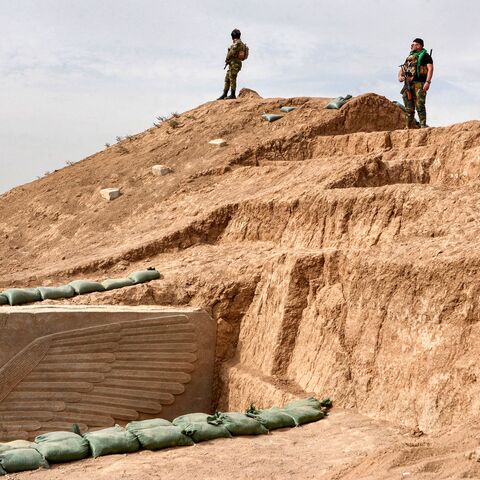 Iraqi security forces stand guard at the site of a newly-unearthed Assyrian Lamassu (human-headed winged bull) sculpture discovered with its entire wings intact by the French archaeological mission at the archaeological site of Khorsabad (also known as Dur-Sharrukin), the former Assyrian capital in the time of Sargon II (721705 BC) in Iraq's northern Nineveh province on October 24, 2023. (Photo by Zaid AL-OBEIDI / AFP) (Photo by ZAID AL-OBEIDI/AFP via Getty Images)