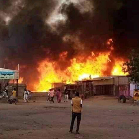 TOPSHOT - A man stands by as a fire rages in a livestock market area in al-Fasher, the capital of Sudan's North Darfur state, on September 1, 2023, in the aftermath of bombardment by the paramilitary Rapid Support Forces (RSF). The conflict between Sudan's army under General Abdel Fattah al-Burhan and the RSF commanded by Mohamed Hamdan Daglo spread in late August 2023 to North Darfur state, with at least 27 localities burned down by the RSF and allied Arab militias, according to the Humanitarian Research L