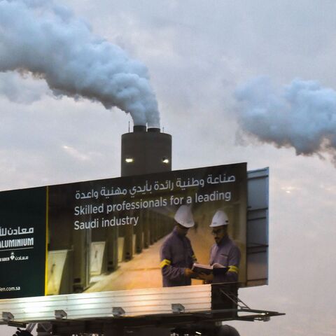 A picture taken on November 23, 2016 shows smoke plumes rising behind a billboard at the Maaden Aluminium Factory in Ras Al-Khair Industrial area near Jubail City, 570 kms east of the Saudi capital Riyadh. 