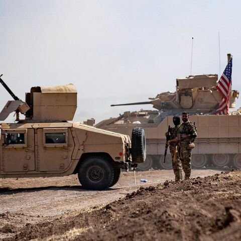 Fighters of the Syrian Democratic Forces (SDF) stand near a US Bradley Fighting Vehicle (BFV) during a joint military exercise with forces of the US-led "Combined Joint Task Force-Operation Inherent Resolve" coalition against the Islamic State (IS) group in the countryside of the town of al-Malikiya (Derik in Kurdish) in Syria's northeastern Hasakah province on Sept. 7, 2022. 