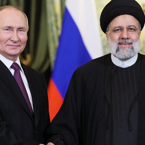 In this pool photograph distributed by Russian news agency Sputnik on Dec. 7, 2023, Russia's President Vladimir Putin (L) shakes hands with Iran's President Ebrahim Raisi during their meeting in the Kremlin in Moscow. 