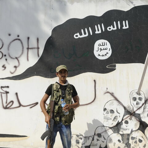 JARABLUS, SYRIA - AUGUST 31: A member of the Turkish-backed Free Syrian Army (FSA) stand guarded in front of a ISIS flag in the border town of Jarablus, August 31, 2016, Syria. Turkish troops and Turkey-backed rebels have been fighting Kurdish-led forces and IS since Turkey's incursion into Syria on Aug. 24. with the swift capture of Jarablus, a town a few km inside Syria that was held by Islamic State.(Photo by Defne Karadeniz/Getty Images)