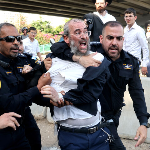 Israeli police disperse Ultra-Orthodox Jews blocking a highway during a protest against possible changes regarding the laws on the military draft from which the Ultra-Orthodox community has traditionally been exempt, in the central Israeli city of Bnei Brak, on June 20, 2024, amid the ongoing conflict between Israel and the Palestinian Hamas militant group. (Photo by JACK GUEZ / AFP) (Photo by JACK GUEZ/AFP via Getty Images)