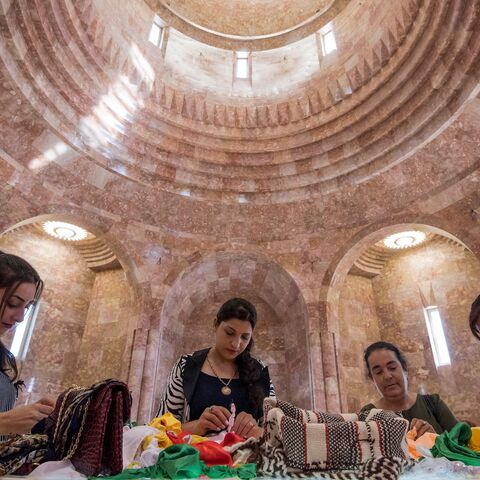 Women worshippers stand at the altar, they pray and tie knots in pieces of cloth that represent their wishes, during their visit to the new Yazidi Temple in the village of Aknalich, 35 kilometres from the Armenian capital Yerevan, on October 11, 2019.