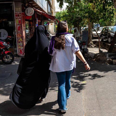 Two Iranian women are walking in the street of Tehran with optional covering.