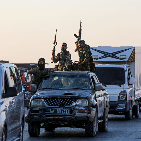 Armed men drive in the back of a pick up truck during protests against Turkey in al-Bab, in the northern Syrian opposition held region of Aleppo on July 1, 2024. A man was killed after and Turkish forces clashed in Syria's Ankara-controlled northwest, a war monitor said, in demonstrations sparked by violence against Syrians in Turkey a day earlier. (Photo by Bakr ALKASEM / AFP) (Photo by BAKR ALKASEM/AFP via Getty Images)