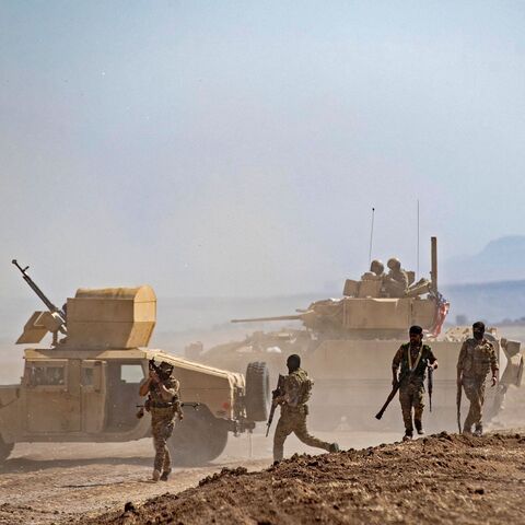 Fighters of the Syrian Democratic Forces (SDF) gather near a US Bradley Fighting Vehicle (BFV) during a joint military exercise with forces of the US-led "Combined Joint Task Force-Operation Inherent Resolve" coalition against the Islamic State (IS) group in the countryside of the town of al-Malikiya (Derik in Kurdish) in Syria's northeastern Hasakah province on Sept. 7, 2022. 