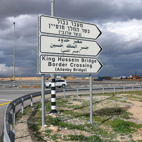 A car drives past a road signal indicating the Allenby (King Hussein) Bridge crossing point to Jordan (background), Jericho, West Bank, Jan. 28, 2021.