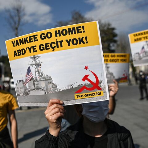 A group of protesters hold placards reading "Yankee go Home - No way to USA," in Istanbul, on April 14, 2021.