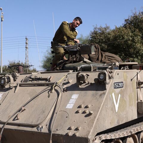 An Israeli soldier works on a tank as troops gather at a position in the upper Galilee region of northern Israel near the border with Lebanon on Nov. 7, 2023.