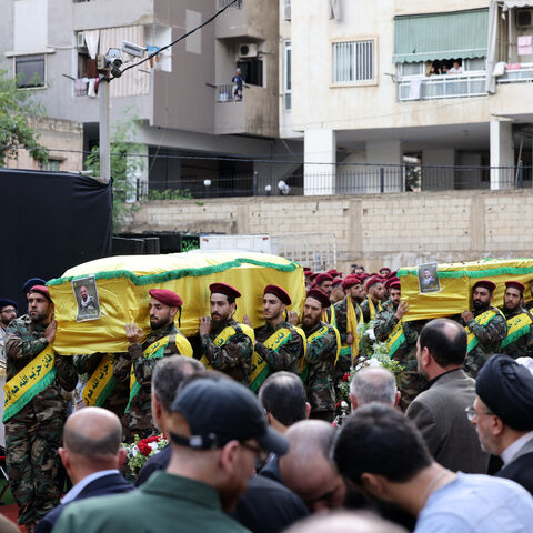 Hezbollah fighters carry the coffins of people killed after hundreds of paging devices exploded in a deadly wave across Lebanon the previous day, during their funeral procession in Beirut's southern suburbs on September 18, 2024. Hundreds of pagers used by Hezbollah members exploded across Lebanon on September 17, killing at least nine people and wounding around 2,800 in blasts the Iran-backed militant group blamed on Israel. (Photo by ANWAR AMRO / AFP) (Photo by ANWAR AMRO/AFP via Getty Images)