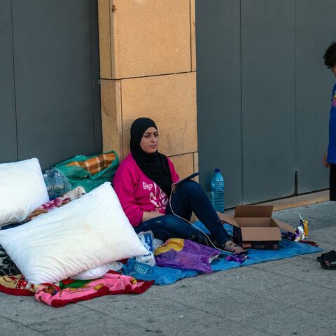 A woman sits with her belongings in Martyrs' Square as she seeks shelter after being displaced by Israeli airstrikes, on Sept. 29, 2024, in Beirut, Lebanon.