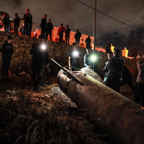 Palestinian youths inspect a fallen projectile after Iran launched a barrage of missiles at Israel.