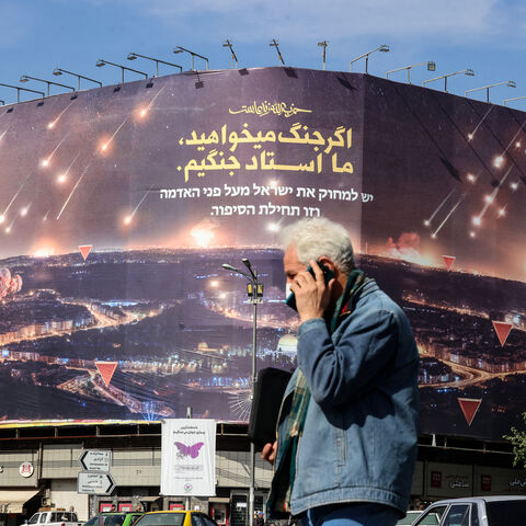 A man walks past an anti-Israel billboard covering the facade of a building in Tehran on October 26, 2024. Residents of Tehran awoke and went about their business as planned on October 26 after their sleep was troubled by Israeli strikes that triggered blasts that echoed across the city. (Photo by ATTA KENARE / AFP) (Photo by ATTA KENARE/AFP via Getty Images)