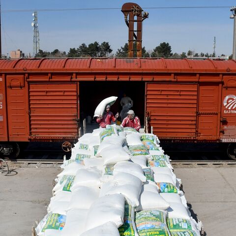 Afghan workers carry flour sacks off a freight train upon its arrival from Uzbekistan, at the border station in Hairatan, Balkh Province, March 5, 2024.