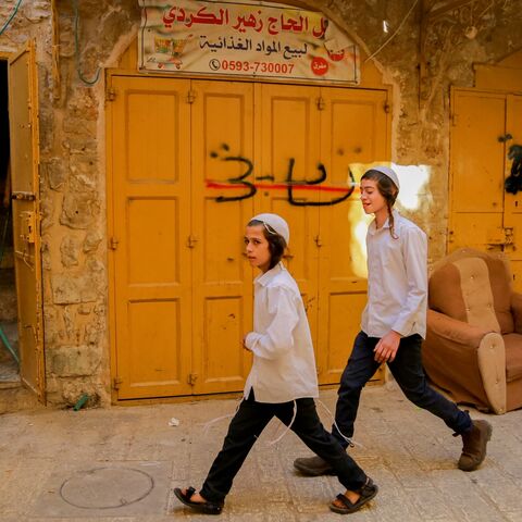 Israeli settlers walk through a street in Hebron's old city. Security is reinforced for the Jewish holiday of Sukkot, West Bank, on Oct. 22, 2024.