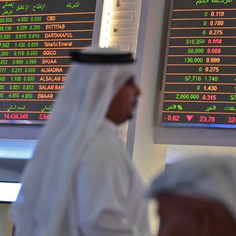 Traders sit below the stock market screens at the Dubai Financial Market, United Arab Emirates, Sept. 16, 2019.