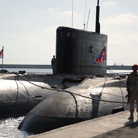 A Russian soldier stands next to submarines at the Russian naval base in the Syrian Mediterranean port of Tartous, on Sept. 26, 2019. 