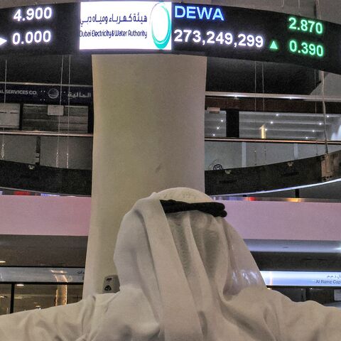 A man watches stock movements on a display at the Dubai Financial Market stock exchange in the Gulf emirate on April 12, 2022.