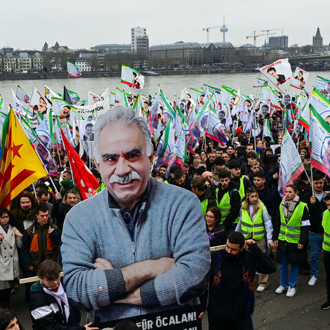 Supporters of the Kurdish community demonstrate with flags and banners on the occasion of the 25th anniversary of the arrest of Kurdistan Workers Party (PKK) leader Abdullah Ocalan on the banks of the Rhine river in Cologne, western Germany, on Feb. 17, 2024. 