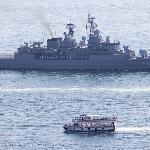 ISTANBUL, TURKEY - SEPTEMBER 27: A ferry passes a Turkish Navy vessel navigating the Bosphorus in a parade to mark the 486th anniversary of the Naval victory of Preveza and naval forces day on September 27, 2024 in Istanbul, Turkey. 16 vessels from the Turkish Naval Forces Command took part in the parade. (Photo by Chris McGrath/Getty Images)